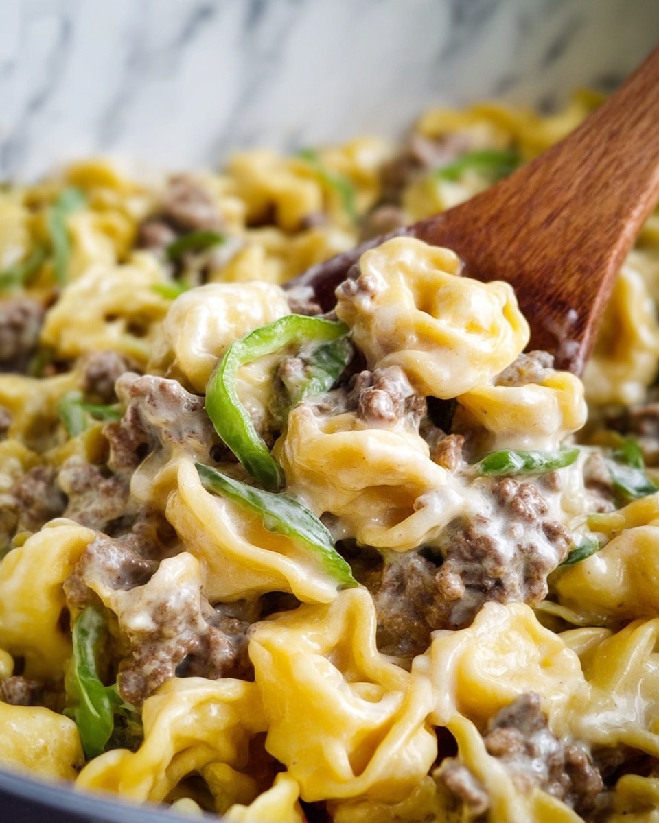Close-up of a creamy pasta dish with three main layers: yellow tortellini pasta forming the base with a smooth, slightly glossy texture; a layer of small ground meat pieces scattered throughout, cooked and slightly brown; and thin slices of green bell pepper adding a fresh, slightly shiny look on top. The creamy sauce is white and thick, evenly coating all layers and creating a rich, smooth texture. A wooden spoon is partially visible, mixing the pasta. The background is a white marbled texture. Photo taken with an iphone --ar 4:5 --v 7