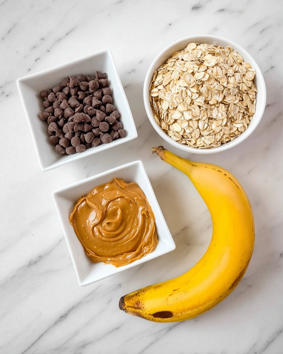 The image shows four separate food items placed on a white marbled surface: a white round bowl filled with light beige rolled oats positioned at the top right; below it, a yellow banana with some brown spots on its peel lies horizontally; to the left of the banana, there is a white square bowl holding smooth, creamy light brown peanut butter; and above the peanut butter, another white square bowl contains dark brown chocolate chips. Photo taken with an iphone --ar 4:5 --v 7