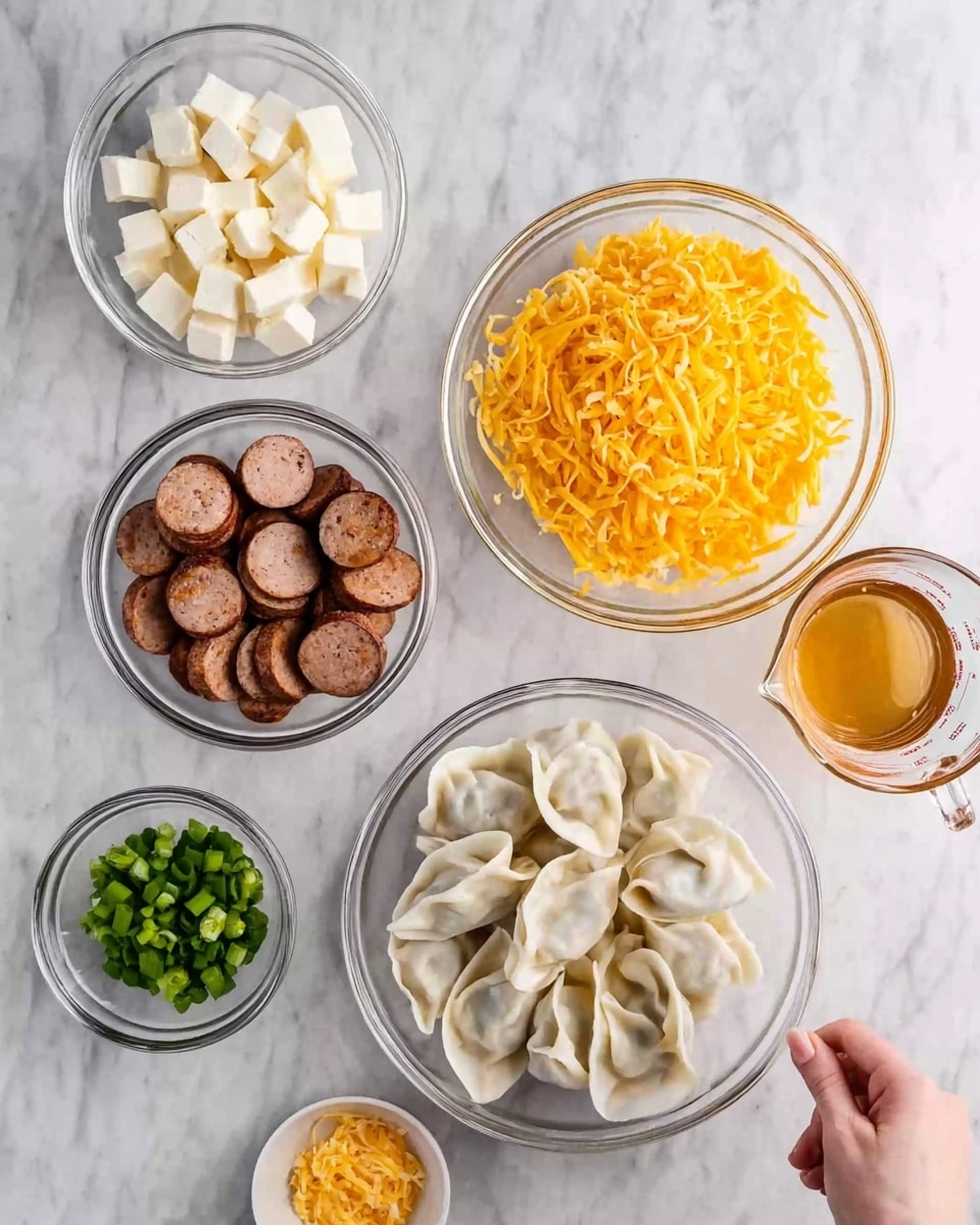 The image shows six clear glass bowls placed on a white marbled surface. The largest bowl at the bottom right contains a pile of uncooked dumplings that are white and folded with a smooth texture. To the left of it is a medium bowl filled with small white cheese cubes. Above that is a small bowl of chopped green onions. At the top center is a large bowl full of shredded bright orange cheddar cheese. To the left of that is a medium bowl with sliced sausage pieces that are brown with a textured, cooked surface. At the top right is a small glass measuring cup with a light brown liquid, likely broth. A woman's hand is reaching from the left side toward the sausage bowl. Photo taken with an iphone --ar 4:5 --v 7