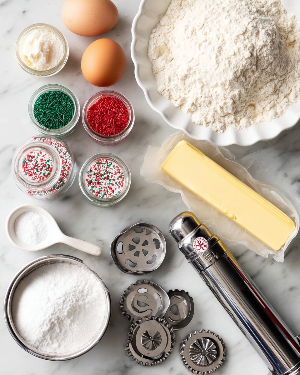 The image shows a white scalloped bowl filled with white flour at the top right. Below it, there is a stick of pale yellow butter partially unwrapped on the white marbled surface. To the left of the butter are two eggs with a smooth, light brown shell. Next to the eggs are four small glass jars of colorful sprinkles in red, green, and mixed colors. There is a metal measuring cup filled with white sugar near the bottom left and a small white bowl with baking powder and a white measuring spoon inside it near the center. A shiny, silver metal cookie press with a black handle and several circular metal discs with different cut-out shapes are arranged near the bottom right of the image. The background is a white marbled surface. Photo taken with an iphone --ar 4:5 --v 7