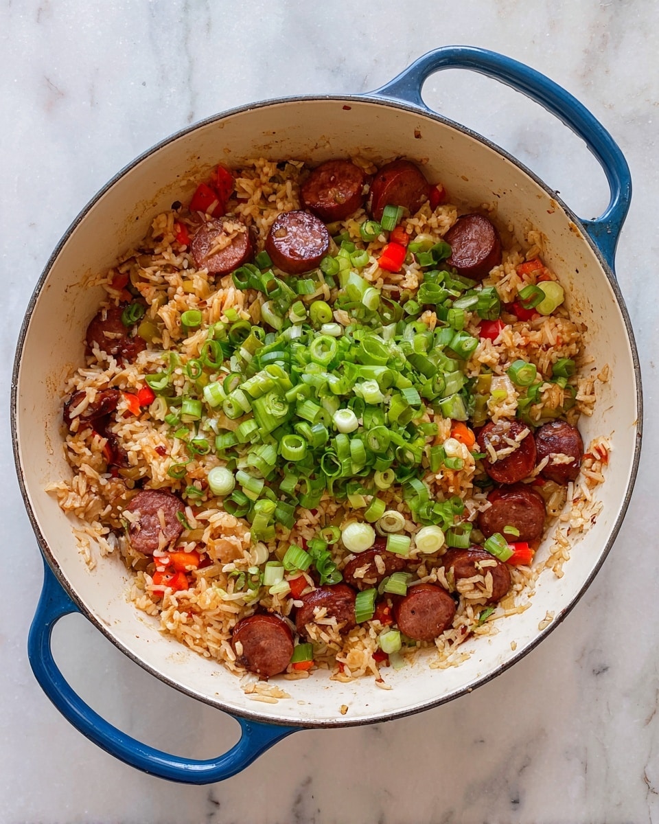 A round white pot with blue handles holds a colorful rice dish. The bottom layer is light brown cooked rice mixed with small pieces of red and orange peppers. Scattered throughout the rice are slices of browned sausage with a rich reddish-brown color. On top, there is a thick pile of chopped green onions adding a fresh bright green color. The pot sits on a white marbled surface. photo taken with an iphone --ar 4:5 --v 7