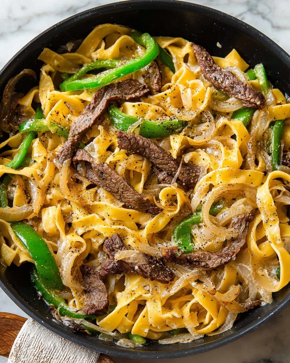 The image shows a black pan filled with a pasta dish made of wide, flat yellow noodles as the base layer, mixed with sautéed light brown onion slices scattered evenly on top. There are bright green bell pepper slices layered throughout, along with several cooked strips of dark brown beef placed on the top, some with browned edges. The dish is sprinkled with ground black pepper, giving it a speckled look. The pan sits on a white marbled surface with a small part of a cloth visible under the edge. Photo taken with an iphone --ar 4:5 --v 7