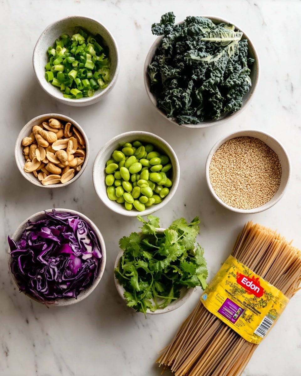 The image shows a collection of ingredients on a white marbled surface. Starting from the top, there is a small white bowl filled with chopped bright green scallions. Below that is another white bowl containing dark green curly kale leaves. To the right of kale, a white bowl is full of light green shelled edamame. Below the scallions and kale, a white bowl holds light brown shelled peanuts, and next to it on the right is a small heap of tan sesame seeds directly on the surface. On the left side near the bottom, a white bowl contains deep purple cabbage pieces. Below the cabbage is a white bowl filled with fresh green cilantro leaves. On the bottom right, slightly overlapping other ingredients, there is a package of yellow and red Eden brand soba noodles, showing long beige soba noodles inside. The composition is clean and colorful against the white marbled background, neatly arranged in a loose grid. photo taken with an iphone --ar 4:5 --v 7