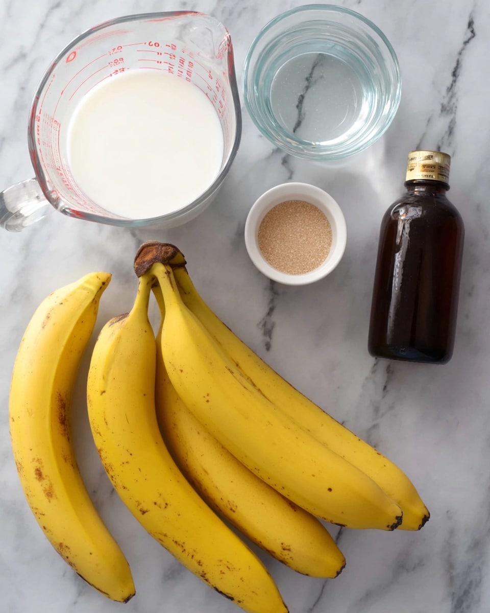 The image shows fresh yellow bananas with some brown spots placed on a white marbled surface. Near the bananas, there is a clear glass measuring cup filled halfway with white liquid, likely milk. Next to it is another clear glass measuring cup containing water. A small white bowl with light brown granulated sugar is placed nearby, and a dark brown bottle of vanilla extract lies on the surface, tilted slightly. All items are neatly arranged on the white marbled background. photo taken with an iphone --ar 4:5 --v 7