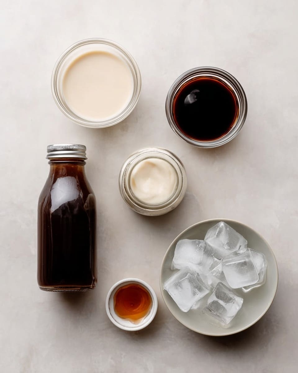 A group of small clear glass bowls and bottles hold different liquids and ice cubes, all set on a smooth white marbled surface. At the top left is a small glass bowl filled with a creamy off-white liquid. Next to it on the right is another small glass bowl filled with a dark brown liquid. To the far right is a small clear glass jar with a light cream liquid and a silver lid. At the bottom left, there is a tall glass bottle with a silver cap holding a dark brown liquid. In the center bottom, a tiny glass bowl contains a small amount of amber liquid. Finally, a round white bowl is filled with several large ice cubes, creating a cool and fresh appearance. photo taken with an iphone --ar 4:5 --v 7