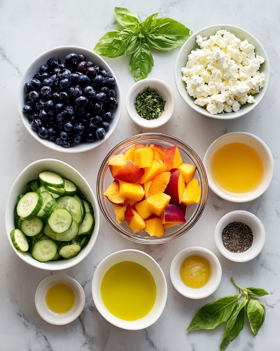 A top view shows a white marbled surface with several white bowls and a clear glass bowl arranged neatly. In the center, the clear glass bowl holds bright orange and red chopped peach pieces. To the left, a white bowl is filled with shiny dark blueberries, and below it, another clear glass bowl contains sliced green cucumbers with a fresh texture. Above the peaches, there is a white bowl filled with white feta crumbles. Around these bowls are small white dishes containing yellow olive oil, clear fresh lemon juice, amber honey, a dollop of pale yellow Dijon mustard, small dark green chopped basil, and a small dish with black and white salt and pepper. A few whole fresh basil leaves lie on the surface near the bowls. All dishes are placed on the white marbled surface. Photo taken with an iphone --ar 4:5 --v 7