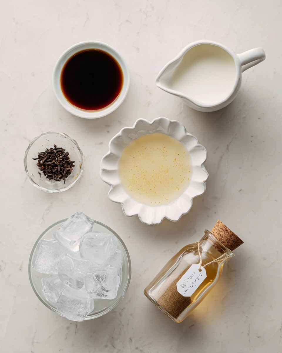 There are five items arranged on a white marbled surface. Starting from the top left, a white small bowl filled with dark brown chai concentrate. To the top right, a white small pitcher filled with white milk. In the center, a white scalloped dish holds a light yellow vanilla simple syrup with visible vanilla seeds. Toward the bottom left, a white pitcher is filled with clear ice cubes. On the bottom right, there is a small glass bottle with a cork containing a brown chai spice blend, labeled with a white tag. The photo taken with an iphone --ar 4:5 --v 7