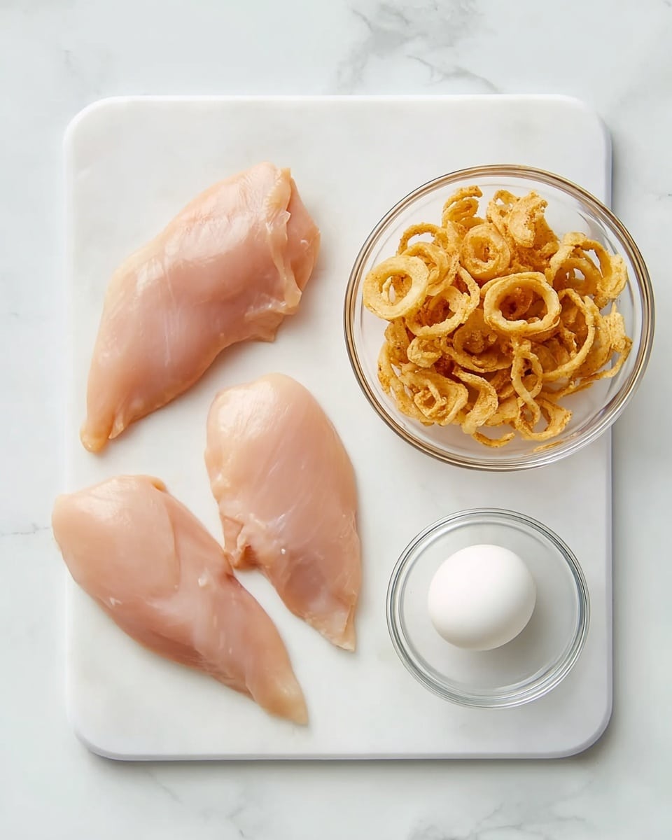 A white cutting board placed on a white marbled surface holds three raw chicken pieces on the left side, each smooth and pink with slight natural texture. On the top right of the cutting board, there is a clear glass bowl filled with crispy fried onion rings, golden brown and light textured. Below that bowl, another clear glass bowl contains a single white egg, smooth and glossy. The scene is bright and clean, showcasing the raw ingredients clearly. photo taken with an iphone --ar 4:5 --v 7