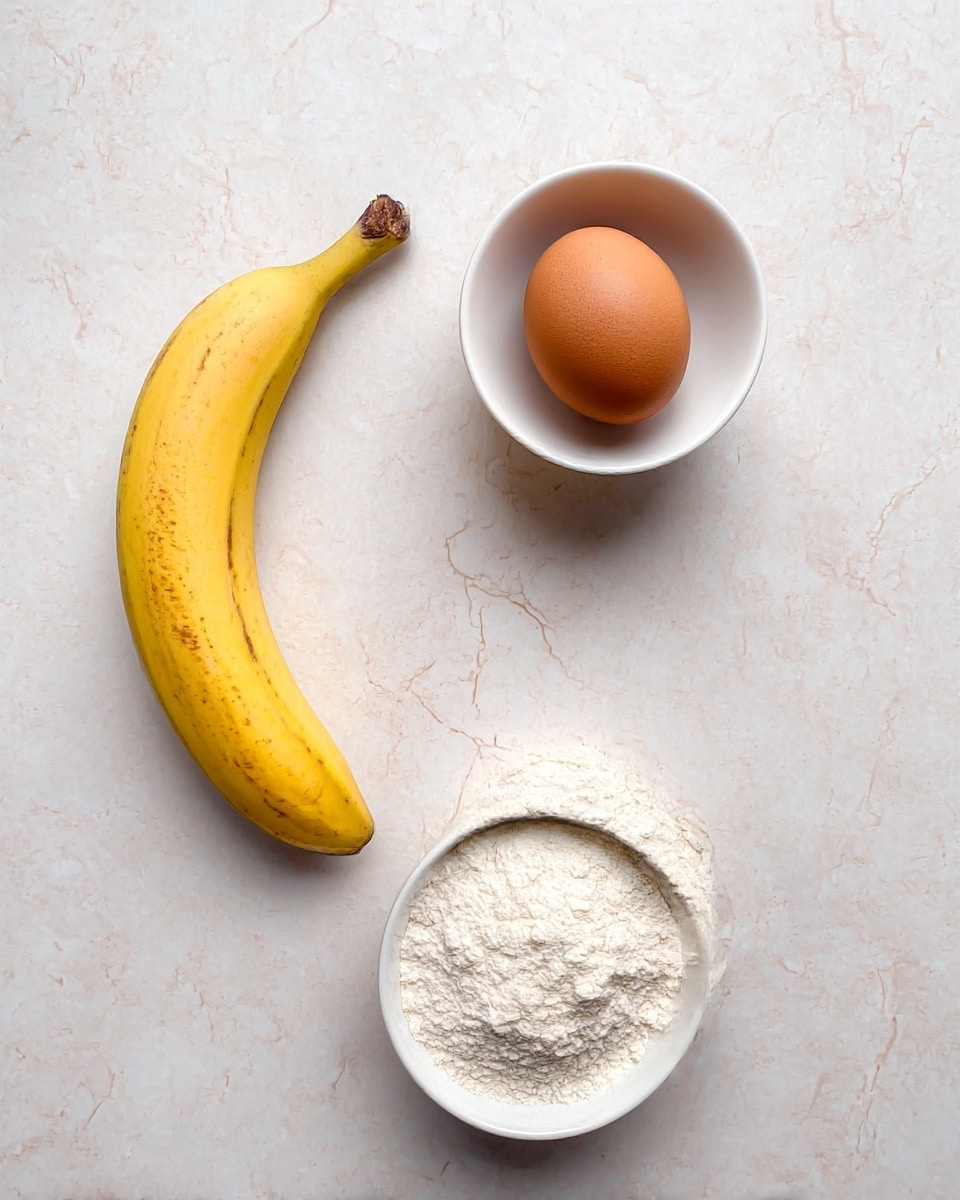 The image shows three ingredients on a white marbled surface: a yellow ripe banana with some brown spots placed at the bottom left, a white small bowl filled with white flour at the bottom right, and a brown egg sitting in a white small bowl at the top center. The layout is simple and clean, with each ingredient well separated from the others, capturing their natural colors and textures clearly. Photo taken with an iphone --ar 4:5 --v 7