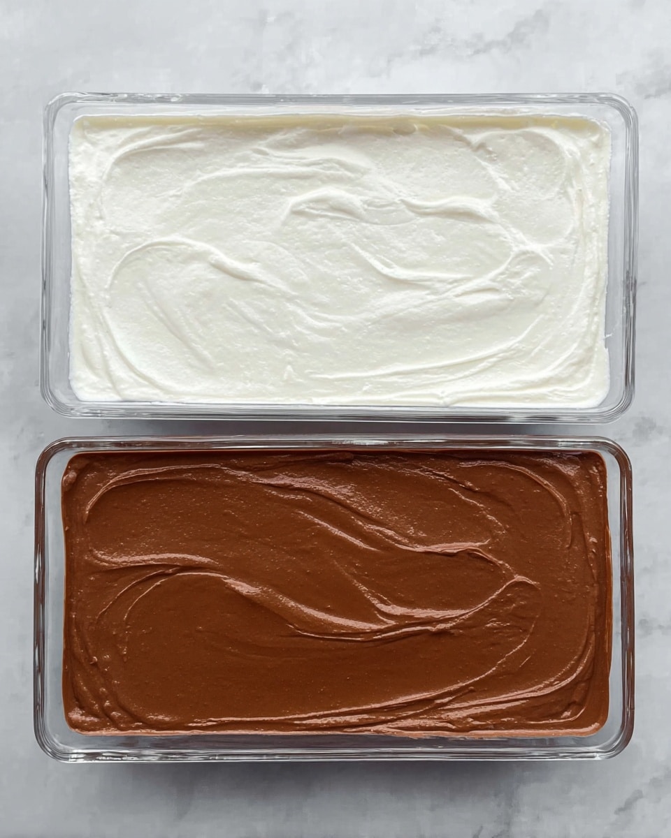 The image shows two clear glass rectangular dishes side by side, both placed on a white marbled surface. The dish on the left contains a smooth, thick, white layer with gentle swirls across the top, evenly spread without any visible gaps. The dish on the right has a thick, smooth chocolate brown layer, also with gentle, soft swirls on the surface, evenly spread like the first dish. Both layers look creamy with subtle texture from the swirls but remain mostly flat and smooth. photo taken with an iphone --ar 4:5 --v 7
