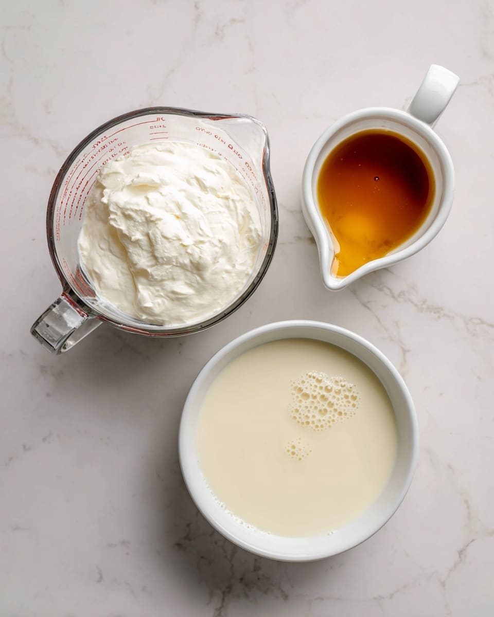 The image shows three containers on a white marbled surface. The largest container is a clear glass measuring cup filled halfway with thick white heavy cream, positioned on the left. Above the measuring cup, there is a white cup with a small spout filled with golden brown vanilla syrup. Below and to the right of the measuring cup, a white bowl holds light creamy 2% milk with small bubbles on its surface. Each container is clearly labeled with bold black text above or beside it. Photo taken with an iphone --ar 4:5 --v 7